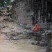un moine est posé tranquillement sur les ruines à observer les touristes sortir du site.