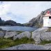 Le phare à l'entrée du fjord de Nusfjord, avec le village au fond